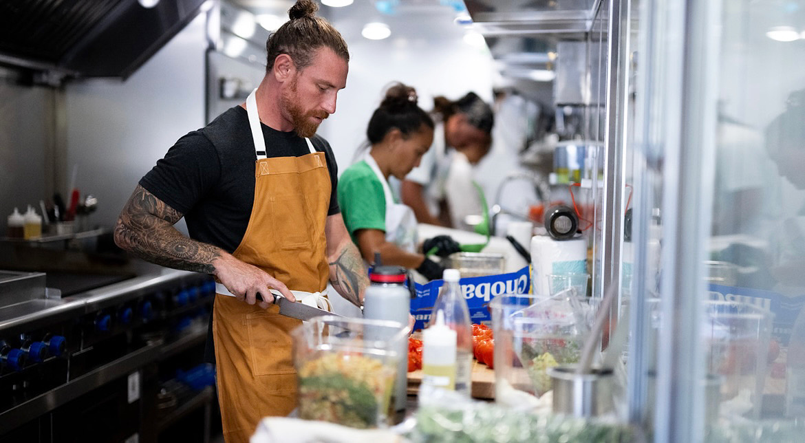 Chef Jason Raffin cooking in a Trailer helping feed people after the fires