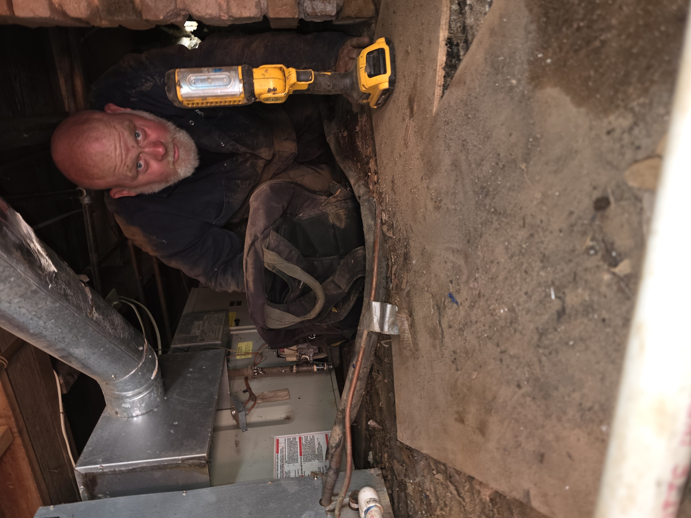 Technician making a repair to an old furnace to get the air conditioner working